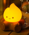 Chibi Campfire Night Light With White Noise Portable Rechargeable Cozy Camping Glow emitting warm light with musical notes visible