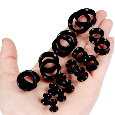 Hand holding Ultra Thin Silicone Ear Gauge Stretching Kit 4mm to 20mm Black Soft Flexible Tunnels Plugs for Earcare