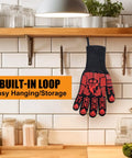 Extreme Heat Resistant BBQ Gloves with built-in loop for easy storage, red silicone non-slip finish, hanging in kitchen.
