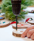 Close-up of Pink Cordless Drill Set for Women in use drilling into wooden crafts with festive designs, showing drill bit in action.