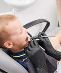 Black nitrile disposable gloves worn by dental clinician during pediatric exam.