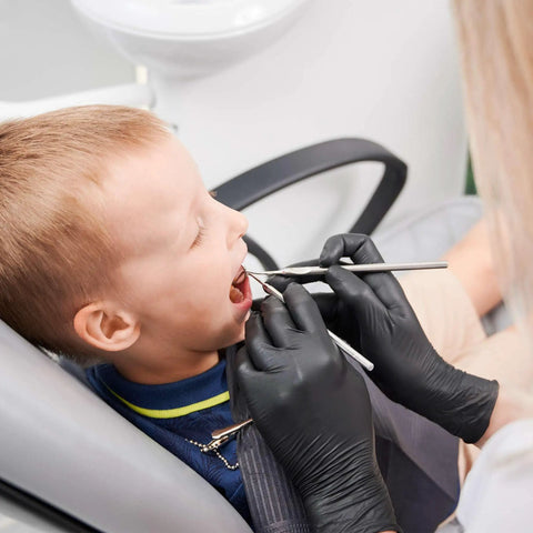 Top Shelf Black Nitrile Gloves Medium Case Of 1000 Disposable Exam Gloves 3 Mil Thick being worn during a child's dental checkup.