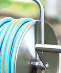 Close-up of Heavy Duty Portable Wall Mount Garden Hose Reel With Durable Stainless Steel Hand Crank and Blue Hose.
