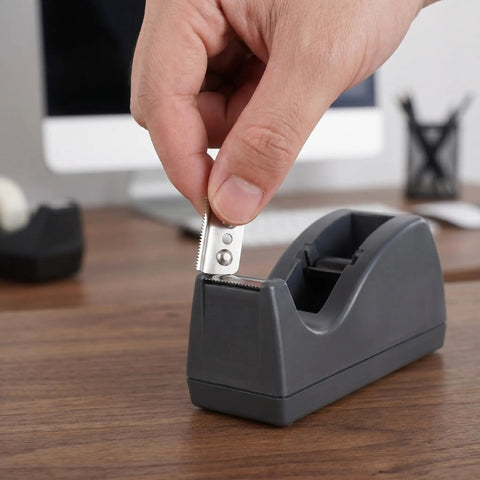 Hand inserting Stainless Steel Serrated Tape Dispenser Blades Replacement Knife into tape dispenser on desk.