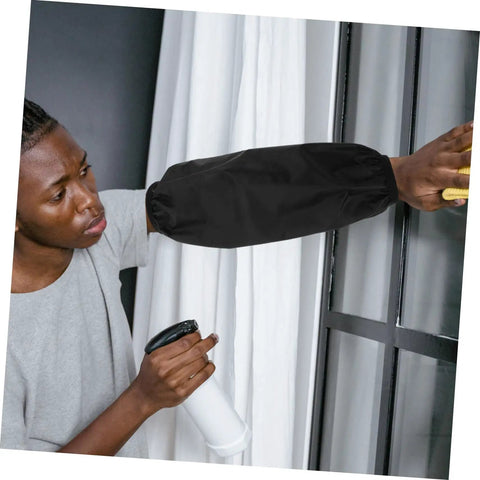 Person using 2 Pack Genuine Oilproof Arm Sleeves Kick Grease To The Curb During Kitchen Grinds Or Yard Work to clean a window.