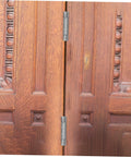 Residential door spring hinge for double-opening wooden doors; stainless steel hinges along the center seam.
