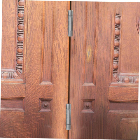 Residential door spring hinge for double-opening wooden doors; stainless steel hinges along the center seam.