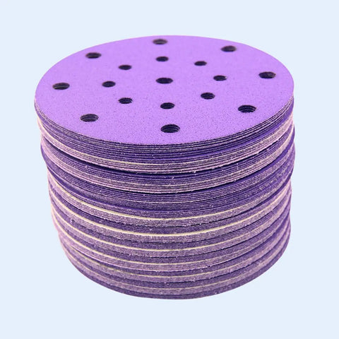 Get Ready To Polish Like A Pro With This Awesome 100 Piece 6 Inch Wet Dry Hook And Loop Sanding Discs Assortment Featuring 320 Grit Plus Many More For Wood Drywall And Metal Projects That Suck Less. Stack of purple 6-inch sanding discs with holes for dust extraction.