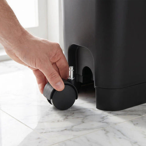 Person attaching an 8 Pack Tough Nylon Stem Swivel Casters 1.5 Inch to a utility bin for easy mobility.