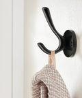 Matte black wall-mounted zinc alloy hook holding a towel, part of 5 Pack Round Coat And Towel Hooks Matte Black Wall Mounted Zinc Alloy Heavy Duty Hangers
