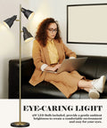 Dope Gold Tree Floor Lamp With Three Adjustable Rotating Lights in living room with person using laptop