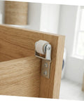 Six Pack Nylon Guide Wheels In Clean White For Furniture Track Systems And Drawer Hardware mounted on a wooden cabinet door.