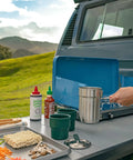 Preparing meal outdoors with Go 4 Piece Stainless Steel Camp Cook Set, 32 ounce pot, lid, cups; perfect for hikers and campers.