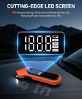 Front view of orange AstroAI digital tire pressure gauge with backlit LED display on car hood.