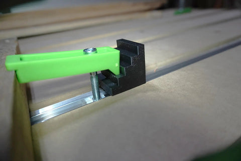 Get Your Work Locked Down Tight With These 10 Pcs 4 Step Clamp Blocks Perfect As CNC Spacer For Hold Down Clamps Super Durable And Precision 3D Printed Gear. Close-up of a green clamp and black CNC step block securing material.