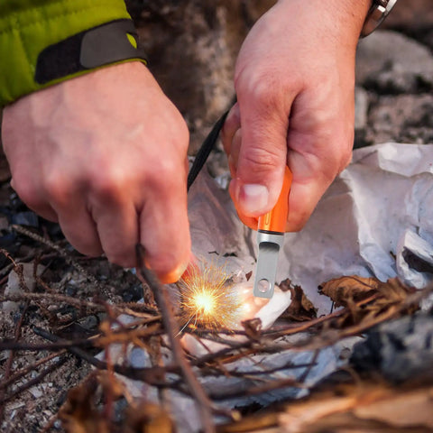Person using Three Pack Ferro Rod Fire Starters With Scraper Striker to ignite fire in outdoor setting