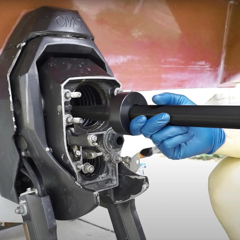 Gimbal bearing alignment/installation tool used on a Mercruiser outdrive; blue-gloved hand inserts a shaft