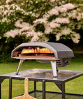Koda 16 Inch Propane Gas Pizza Oven With 28 MBAR Regulator And Hose Outdoor Portable Oven in Foundry Black on a metal table.