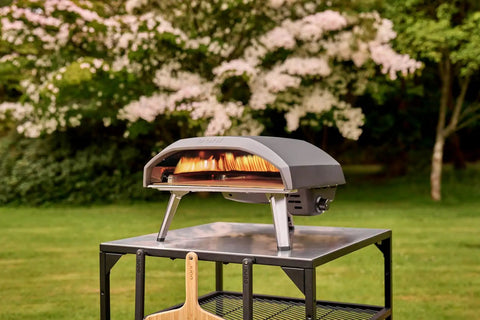 Koda 16 Inch Propane Gas Pizza Oven With 28 MBAR Regulator And Hose Outdoor Portable Oven in Foundry Black on a metal table.