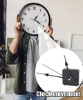 Person holding clock with Ultra Quiet Quartz Clock Movement Replacement Kit inset, showing silent wall clock mechanism.