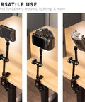Beefy Aluminum C Clamps With 1/4-20 And 3/8-16 Sockets, Dual Mounting Threads holding cameras and device on wooden desktop.