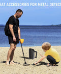 Man and boy using Heavy Duty Black Sand Scoop And Shovel for beach treasure hunting with metal detector by the shore.