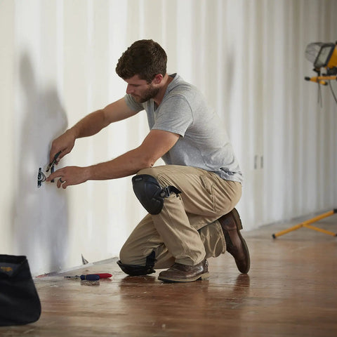 Man wearing 1MN-350 Tuff Shell Knee Pads With Lightweight Ergonomic Design For All Day Comfort And High Density EVA Foam Liner working on wall