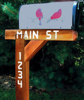 Wooden mailbox post with white stenciled street name and numbers, showcasing use of sign making router kit templates.