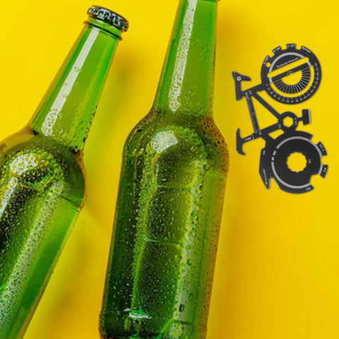 Bike Shaped Multitool Keychain Portable Stainless Steel Bicycle Tool near green bottles on yellow background.