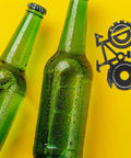 Green bottles next to Bike Shaped Multitool Keychain For Outdoor Use Durable Stainless Steel Bicycle Tool With Handy Functions Compact Pocket EDC For Men And Cyclists Rugged Go To Gear.