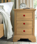 Totally Rad Red Ceramic Cabinet Knobs on a wooden nightstand with three drawers, enhancing modern bedroom decor.