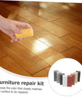 Hand using Floor And Tile Repair Wax Kit For Porcelain And Ceramic Tiles Quick Drying Hard Wax Filler on wood flooring
