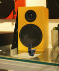 Rigid L Shape Plate Mount Casters for tool box next to a yellow speaker, heavy duty PVC rubber wheels