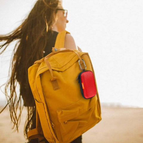 Small Red Rectangular Eva Case With Hella Tough Crush Proof Hard Shell And Smooth Zipper Mesh Pouch For Charger Cables Earbuds Memory Cards And Everyday Carry attached to a yellow backpack.