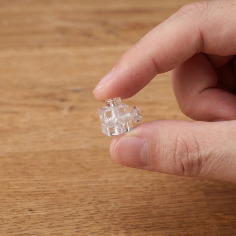 Hand holding Clear Acrylic 90 Degree Corner Brackets Set With M4 Screws 20 Pack Cube Shelf Supports close-up view