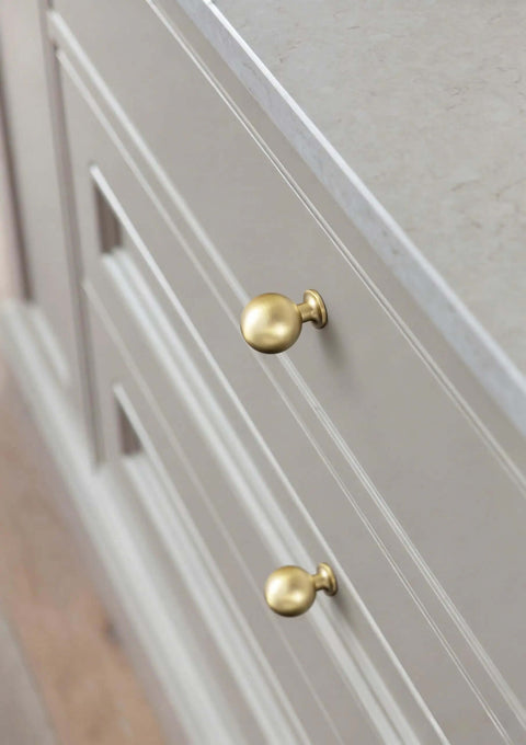 Soft Champagne Bronze Cabinet Knobs 12 Pack 1-3/16 Inch Round Zinc Alloy Hardware on white cabinet drawers