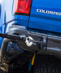 Tough As Nails 3/8 Inch By 12 Inch Soft Shackle With Heavy Duty Dyneema Fiber attached to a blue pickup truck for off-road recovery.