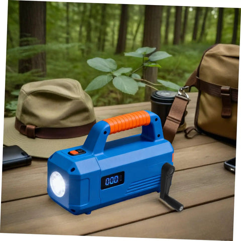 Blue portable flashlight with ergonomic orange handle and digital display, placed on a wooden table in a forested environment.