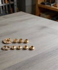 Score This Killer Acrylic Router Base With Centering Pin And Bang For Buck Ten Piece Brass Guide Bushing Set 10mm To 30mm Comes With Nifty Storage Case Ready For Fast Trim And Pattern Routing Work featuring brass guide bushings arranged on a wooden surface.