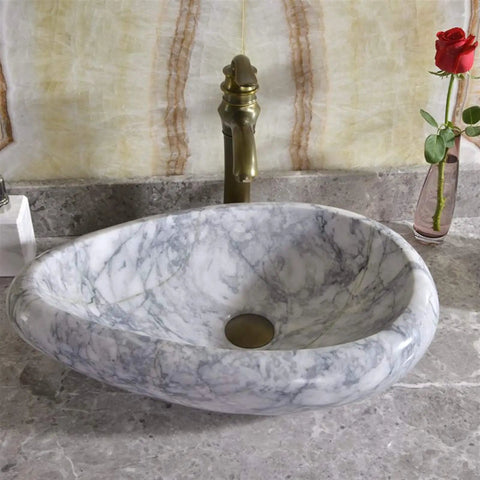 Sleek Marble Vessel Sink For Modern Bathrooms Featuring An Oval Countertop Basin Design with polished marble surface and golden faucet.