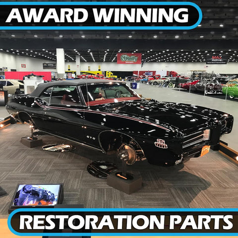 Award-winning restored black GTO car displayed indoors at auto show, surrounded by other vintage cars.