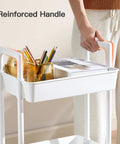 Person holding reinforced handle of a Three Tier Rolling Cart Organizer With Lockable Wheels and Reinforced Handle, Lightweight Plastic Utility Cart.