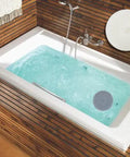 Slick Six Inch Silicone Tub Stopper Two Pack Soft Drain Plug Hair Catcher in a bathtub with water, showing gray and white stoppers.