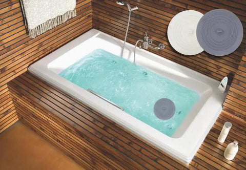 Slick Six Inch Silicone Tub Stopper Two Pack Soft Drain Plug Hair Catcher in a bathtub with water, showing gray and white stoppers.