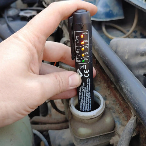 Person using Brake Fluid Tester Pen with 5 LED Indicators for DOT3 DOT4 DOT5.1 Testing in car engine bay for moisture check.
