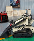 Beast Mode Skid Steer Loader With Reinforced Frame Built For Mining, shown in a workshop, with tools and metal tracks visible.