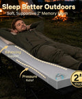 Person resting on 2 Inch Memory Foam Comfy Camping Cot Pad For Folding Cots With Removable Cover Non Slip Waterproof Bottom