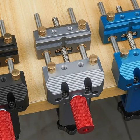 Premium Blue Aluminum Bench Vise With Sliding Screw And Brass Jaws For CNC Machining, Home Workshop Clamping, And Precise Mini Table Tool Work. Close-up of colorful vises on workbench.