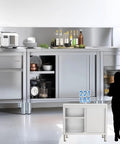Built Tough Heavy Duty Prep Workbench With Sliding Doors Rust Resistant Stainless Steel Kitchen Table with storage and kitchen items.