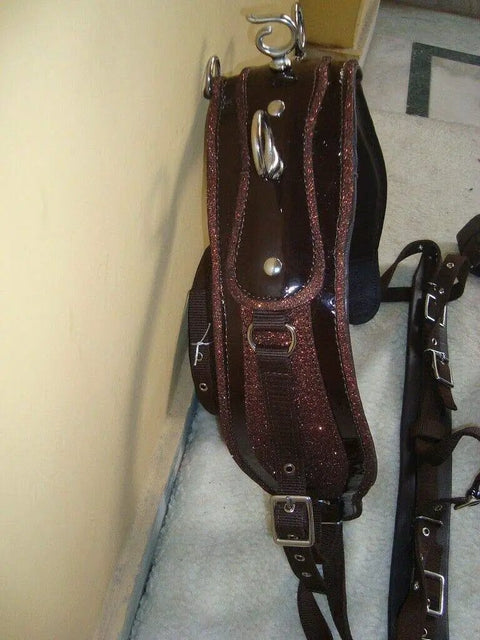 Nylon Horse Driving Harness With Patchwork Bridle hanging, showing durable double stitch construction and synthetic leather padding.